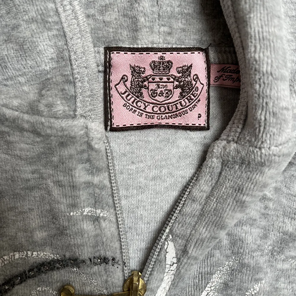 Säljer en ljusgrå kofta från Juicy Couture! Koftan är i storlek P (petite) vilket motsvarar ungefär en XS eller XXS. Koftan är i fint skick förutom att loggan spruckit lite (se bilder). Säljs för 300 kr. . Hoodies.