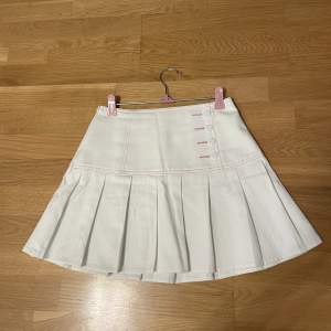 En söt vit veckad kjol i storlek XS, köpt från Shein men ej använd då den är för liten.