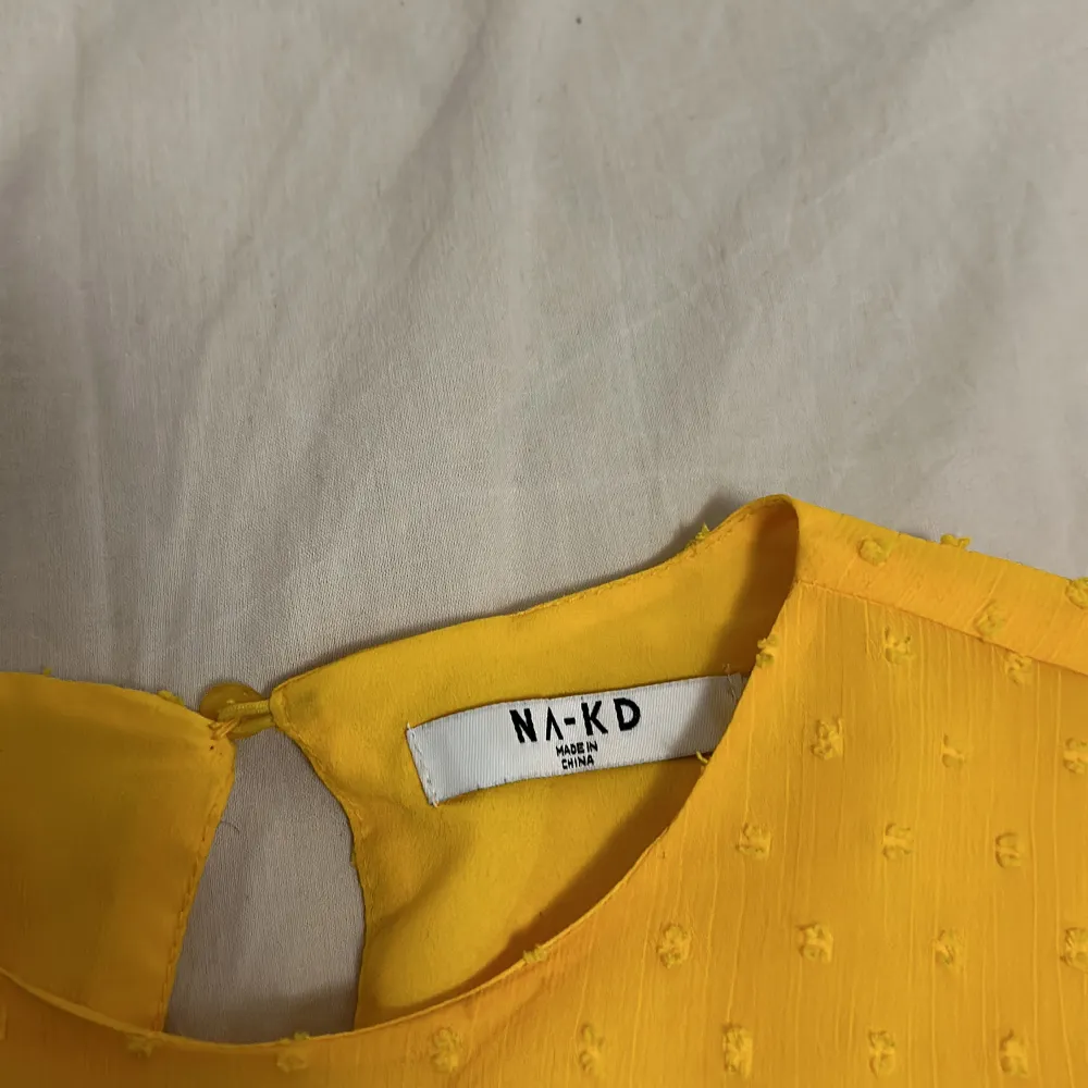En gul blus från NA-KD. Har använts ett antal gånger men är fortfarande i bra skick. . Blusar.