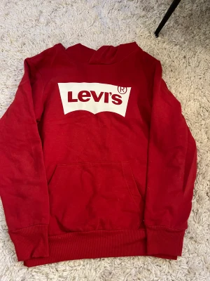 Levis hoodie - En röd Levis hoodie i storlek 152/xxs. Helt ny aldrig använd. Perfekt nu inför kallare säsonger.