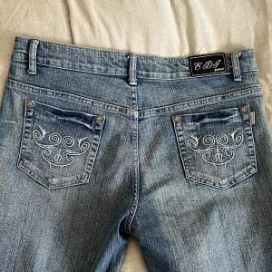 Snygga jeans med fina broderi och rinestones. Alla knappar har blomdetaljer. Dem är thriftade :) Okänt märke  44cm midja 77cm längd från inseam 