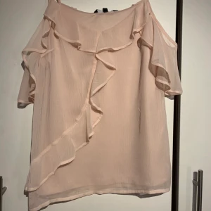 Linne med ärmar - Ett rosa fint linne med tyg som hänger över armarna som ger linnet en mer uppklädd känsla. 