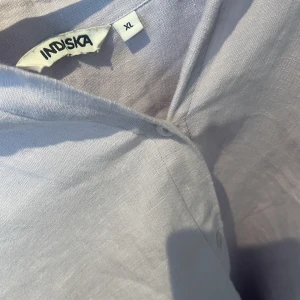 Linne skjorta lila  - En lila linneskjorta från indiska, ganska stor i storleken. Färgen blir inte helt rättvis på bild, men är pastell-lila. Använd fåtal gånger 