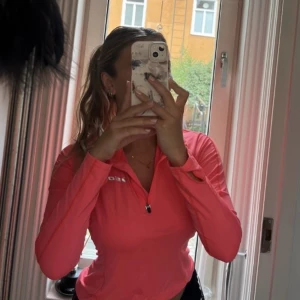 Långärmad träningströja  - Tunn långärmad tränings tröja med 1/4 dragkedja. Färgen är korall/rosa. Används fåtal gånger, mycket bra skick!