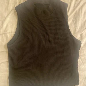 Linne  - Ett svart linne med ”polohals” 