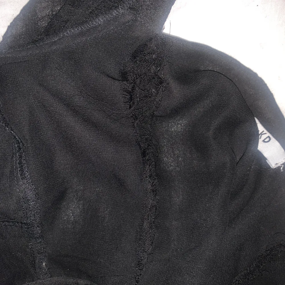 Denna blus är från NA-KD i ett svart, rutigt, tunnt och  genomskinligt material. Dock är den lite sönder på ena sidan inuti. (Syns inte när den är på) Det går att sy ihop den om man känner för de. Frakt ingår i priset:). Blusar.