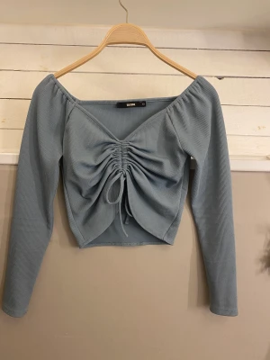 Bikbok tröja  - Hej tänkte sälja denna tröja. Använd men inga skador så den är i bra skick. Väldigt fin färg på den, säljer för att den blivit för liten. Man kan justera hur den ska se ut på framsidan med banden. Mer bilder frågor skriv till mig. 💕