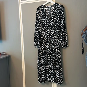 Klänning  - Jätte fin mönstrad lång klänning med v-ringning. Jätte fint skick, knappt aldrig använd. (Frakt tillkommer) 