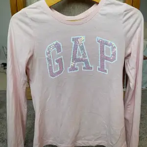 En jättefin långärmad gap tröja men paljetter på gap bokstäverna. En fin rosa färg. Använd ett fåtal gånger.