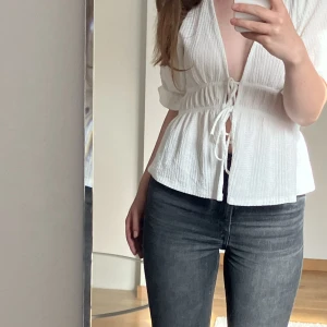 Vit blus  - Skick: Mycket bra  Köpte denna söta blusen  för mindre än ett år sedan och skicket är fortfarande mycket bra. Passar med alla underdelar, kjol såväl som jeans. Knutarna går att knyta upp om man föredrar det. 