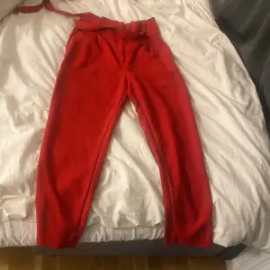 Röda kostymbyxor