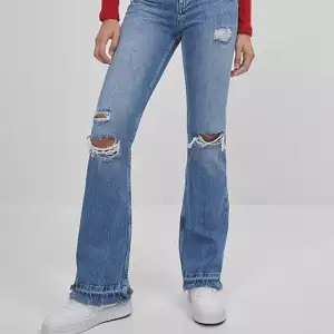Jeans i bootcut/flare modell och slitningar. Storlek 38.