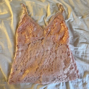 Rosa spetslinne - Jättefint rosa spetslinne, köpt på plick men aldrig använt. Täckande spets över bysten, genomskinlig spets på resten. Justerbara band, stängs i sidan med en dragkedja❤️‍🔥