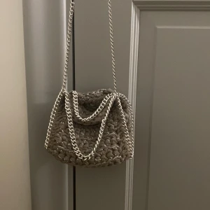 Väska  - Jätte snygg stella mcartney liknande väska från stazzi remake. Den är grå beige aktig med silver tråd i. Köpt för 510kr men säljer för 400 kr! Pris kan diskuteras🩷