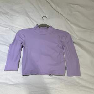 En lila tröja med öppen rygg som går att dra åt som man vill