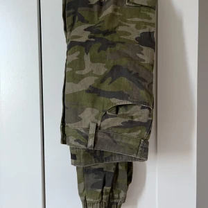 Camou Cargo Pants  - Ett par camouflaguefärgade cargo panta från BikBok. Fint skick men några trådar lösa vid en knapp (se bild 3). Frakt tillkommer