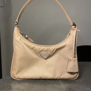 Prada Re-Edition 2005 Re-Nylon mini bag - orginalpris 11 900 kr. Finns en svart fläck på sidan av väskan vilket gör att priset är billigt. bild kan skickas på äkthetskort. Dustbag tillkommer. 