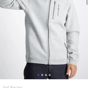 Sail racing hoodie! - Säljer min gråa sailracing hoodie i storlek 160. Skulle säga att storleken passar alla under 167 som ungefär en XS/XXS. Ganska använd och lite missfrägade dragkedjor, därav priset. Nypris är 999kr💘 Skriv för fler bilder.