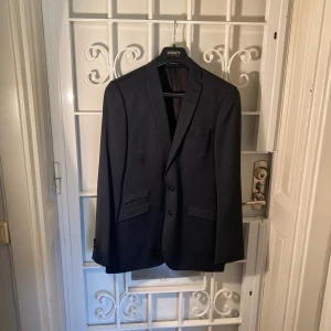 Blazer i navy blue – Tiger of Sweden - Marinblå kavaj från Tiger of Sweden. Modell: Nedvin.  Mycket fint skick.  Storlek: 148.  Yttertyg: 100 % ull. Foder: 100 % viskos.  Hämtas i Stockholm, Vasastan. Eller skickas