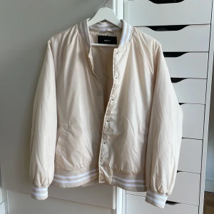 Höst/vår jacka - Snygg beige jacka från bikbok, med modell liknande av en bomberjacka. Den är i storlek m men skulle säga att den även passar som s, även xs om man vill ha lite oversized.