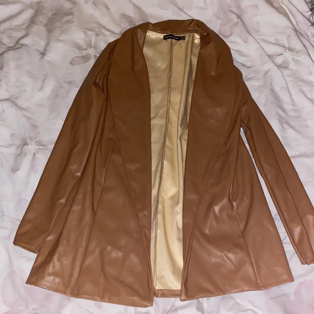 Detta är en tunn brun skinn jacka. Den är väldigt slim vid ärmarna och ger en elegant outfit.. Jackor.