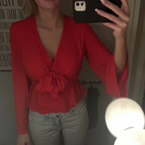 Röd blus med knytning - Jättefin röd blus med knytning framtill. Vida armar. Bra skick. 