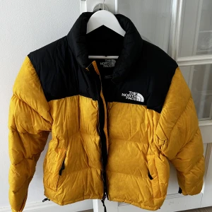 North Face dunjacka gul - Säljer en fin North face dunjacka i gult. Använd ca 2 vintrar. Inga skavanker om något lite smuts nånstans.