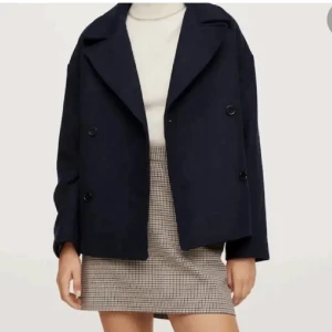 Kort kappa - Jättefin, eftertraktad marinblå kappa från Mango, finns ej att köpa längre! Använd men i mycket bra skick. Perfekt nu till hösten och varmare dagar på vintern. Hör av dig om du har frågor eller vill ha fler bilder🫶🏼