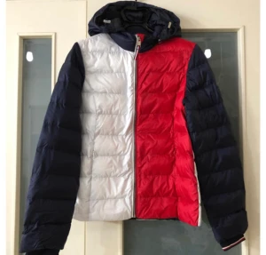 Tommy Hilfiger dunjacka i nyskick! - Exklusiv kvalitetsjacka från Tommy Hilfiger med fina egenskaper, bland annat avtagbar luva. Endast testad så i nyskick, som oanvänd.   Nypris 2500:-