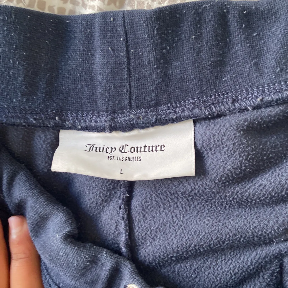 Säljer mina mörkblå juicy couture byxor, byxorna är använda och har tvättats i tvättmaskin ett par gånger, säljer byxorna för dom används inte längre och ligger bara i min garderob, storlek L på byxorna, finns inget snöre till byxorna då snöret e borta . Jeans & Byxor.