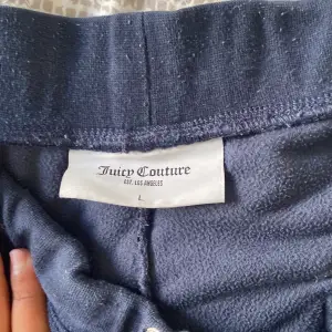 Säljer mina mörkblå juicy couture byxor, byxorna är använda och har tvättats i tvättmaskin ett par gånger, säljer byxorna för dom används inte längre och ligger bara i min garderob, storlek L på byxorna, finns inget snöre till byxorna då snöret e borta 
