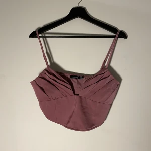 Crop Top - Oanvänd topp med urringning och dragkedja på sidan. 