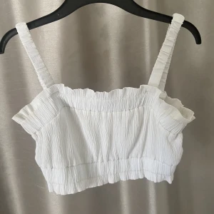 Kort volangtopp - En så fin topp från HM med volangdetaljer. Toppen är vit och sitter jättefint. Knappt använd, 250kr ny.