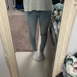 Ljusblåa jeans med hål  - Skinny är ju inte det mest populäraste men ändå värt ett försök att sälja dem här, dem är low waist och sitter rätt så bra.