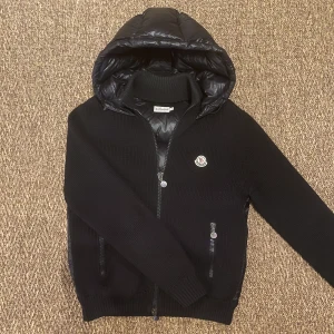 Moncler Cardigan - Säljer en supersnygg cardigan som inte längre tillverkas, skick 8/10! Storlek L, fits M-L. Den är av den tjockare varianten, passar därmed perfekt inför kyligare tider. Nypris 9K, mitt pris 4399kr!
