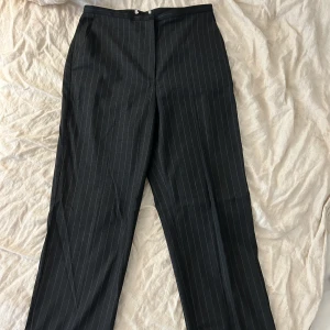 Utsvängda kostymbyxor  - Raka kostymbyxor med medelhög midja. Använda men i gott skick.