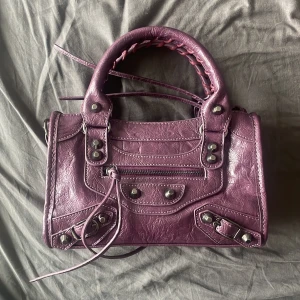 Väska - Inte äkta! Men fortfarande sjukt snygg, i en mörklila färg Den är 24 cm lång och 16 cm hög!