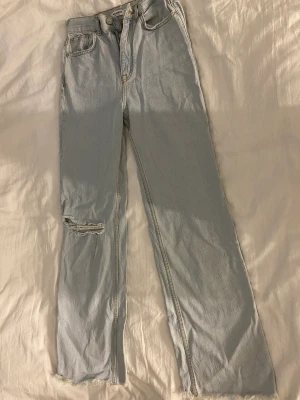 Ljusblåa jeans med slitet hål - Använd några gånger och är i ett bra skick. 