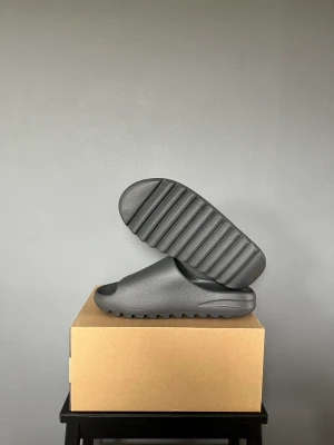 Yezzy Slide Granité  - Yezzy Slide Granite  Storlek: 48,5 Skick: DS (Helt Nya) Pris: 1100kr  Allt Medföljer   