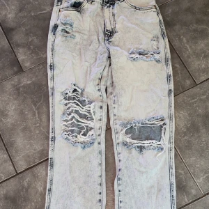 Ljusa jeans - Jeans från JFR, slits i bensluten, hög midja, lös modell. Några trådar på knäna har gått av men i övrigt hela och fina. 