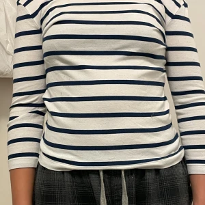 Randig tröja - En riktigt fin tröja som har används en gång på en fest men aldrig mer. Den är färgen vit och mörk blå. Den kan passa någon som har S för den är stor  i storleken.