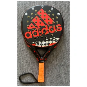 Adidas Adipower Woman lite, Padelrack - Säljer mitt Adidas padelrack. Använt adipower i mycket fint skick, några få små lacksläpp, inga sprickor. Ett runt nybörjare racket, vikt; 355g 1st ny orange linda medföljer Skick: 9/10 Hämtas i Kristinehamn eller skickas med postnord- OBS! frakt 74kr