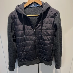 Hoddie - Ralph Lauren - Hoodie i stickat, fodrad fram, dragkedja framtill och dolda fickor med dragkedja i sidorna. I mycket gott skick - inköpt våren 2023 men nu tyvärr för liten i storleken. Byter gärna till större storlek alternativt säljer!