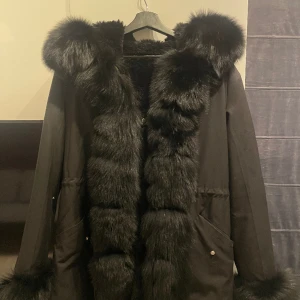 Päls jacka  - Jackan är köpt vintern 2021 från Holmlunds. Den är storlek M och har bara använts ett fåtal gånger. Har en dragkedja och knappar. Jackan är i väldigt bra skick och varm till kommande vintrar. Nypris 4300kr,säljer den för 3000. Äkta päls!.