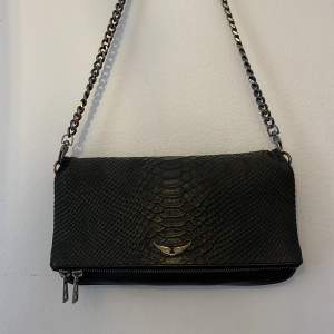 Zadig handväska som min tjej fick i present men använd ytterst lite Inga hål, skador m.m :) Krokodil skinn men en svart/mörkgrå ton. 