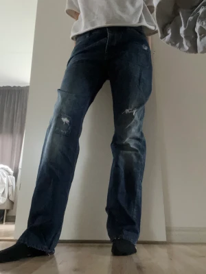 Lågmidjade Tommy hilfiger jeans - Säljer dessa lågmidjade Tommy Hilfiger jeans som sitter lite loose, med hål💙är 172