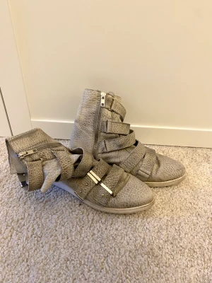 Designers remix charlotte eskildsen skor - Säljer dessa coola skor från designers remix charlotte eskildsen. De har ett jättecoolt ormskinns-liknande mönster och är i ett använt skick🤍 Storlek: 36, men passar även 37! Färgen är grå/ ljusgrön, med silvriga detaljer🤗 Köparen står för frakten!😚