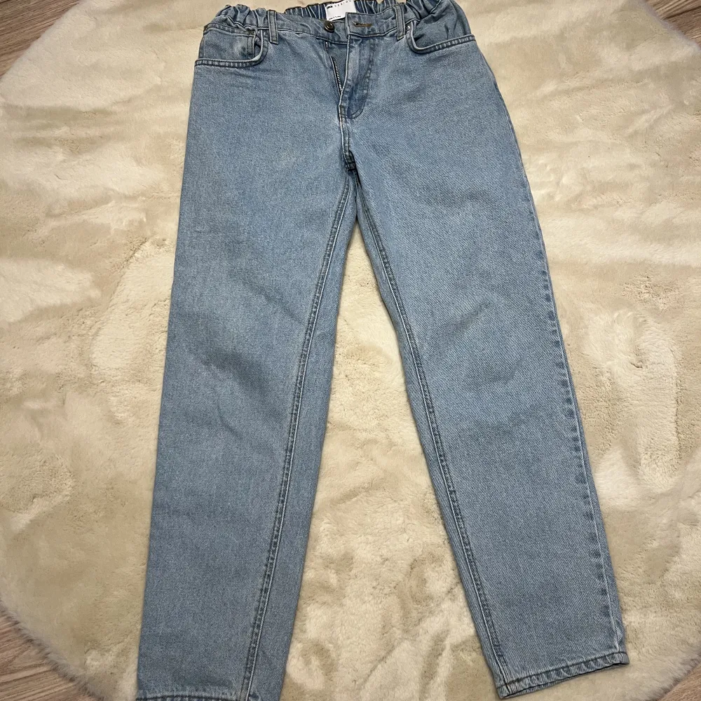 Ljusblåa Jeans i nyskick från ASOS med elastiskt midja och normal passform. Storlek 30/32 . Jeans & Byxor.