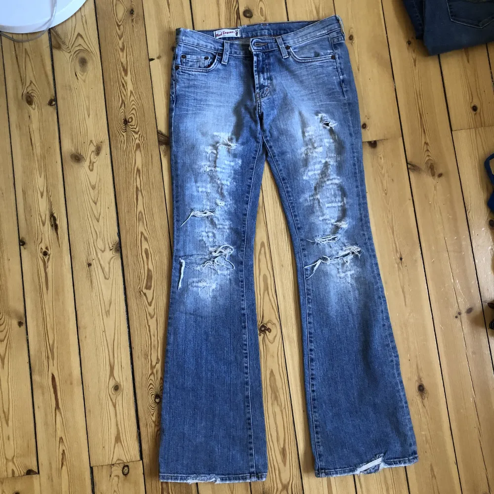 Lågmidjade utsvängda jeans med hål/slitningar på låren, bra skick! Midjemått: 77cm Innerbenslängd: 83cm. Jeans & Byxor.