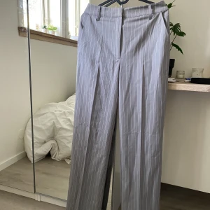 Kostymbyxor  - Säljer dessa skitsnygga grå&vitrandiga kostymbyxorna från bikbok! De är helt oanvända med prislappen kvar. Jag kan tyvärr inte längre knäppa dessa och därav säljer jag dem. De är köpta för 499kr! 